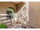 Inviting entryway with a security door, a arched window, and decorative rock landscaping at 930 N Mesa Dr # 1023, Mesa, AZ 85201