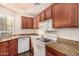 Well-lit kitchen featuring wooden cabinets, granite countertops, and modern white appliances at 930 N Mesa Dr # 1023, Mesa, AZ 85201