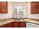 Bright kitchen showcasing a double sink, wood cabinets, granite counters, and stainless steel appliances at 930 N Mesa Dr # 1023, Mesa, AZ 85201