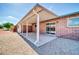 Exterior view of back patio with concrete floor, brick wall, and sliding glass door at 9639 W Cinnabar Ave # A, Peoria, AZ 85345