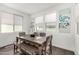 Bright dining area with a wooden table, bench seating, and decoratively framed windows on a sunny day at 9901 E Tamery Ave, Mesa, AZ 85212