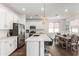Bright and airy kitchen featuring modern appliances, an island with bar stools, and an adjacent dining area at 9901 E Tamery Ave, Mesa, AZ 85212