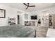 Spacious main bedroom with a ceiling fan, a desk, a view of the main bathroom, and neutral carpet at 9901 E Tamery Ave, Mesa, AZ 85212