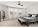 Cozy main bedroom with neutral colored carpet, a large bed, and a bright window at 9901 E Tamery Ave, Mesa, AZ 85212