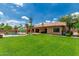 This backyard has lush green grass, a sparkling pool, and a covered patio at 10105 E Larkspur Dr, Scottsdale, AZ 85260