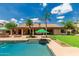 Beautiful backyard featuring a sparkling pool, lush landscaping, covered patio, and well manicured lawn at 10105 E Larkspur Dr, Scottsdale, AZ 85260