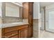 Bathroom features a granite countertop and vanity with wood cabinets and framed mirror at 10105 E Larkspur Dr, Scottsdale, AZ 85260