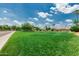 Expansive front yard with lush grass, a mature tree, and neighborhood homes in the background enhancing curb appeal at 10105 E Larkspur Dr, Scottsdale, AZ 85260