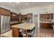 A spacious kitchen with stainless appliances, an island with seating, granite countertops, and dark wood cabinets at 10105 E Larkspur Dr, Scottsdale, AZ 85260