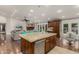 Open-concept kitchen with island seating, stainless appliances, dark cabinets, and hardwood floors at 10105 E Larkspur Dr, Scottsdale, AZ 85260