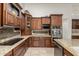 Kitchen featuring dark wood cabinetry, granite countertops, stainless steel appliances, and tile backsplash at 10105 E Larkspur Dr, Scottsdale, AZ 85260