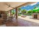 Covered patio area for entertaining, featuring a ceiling fan and outdoor furniture with pool view at 10105 E Larkspur Dr, Scottsdale, AZ 85260