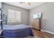 Cozy bedroom with a TV, wood-look floors, a dresser, and natural light from the window at 10448 E Conieson Rd, Scottsdale, AZ 85255