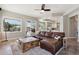 Spacious living room featuring a large leather sectional, rustic coffee table, and views of the outdoor pool area at 10448 E Conieson Rd, Scottsdale, AZ 85255
