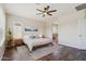Bright main bedroom featuring wood floors, ceiling fan, ensuite bathroom, and comfortable furnishings at 10448 E Conieson Rd, Scottsdale, AZ 85255