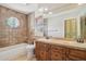 Charming bathroom with dual sinks, warm lighting, and a large framed mirror at 12183 E Mercer Ln, Scottsdale, AZ 85259