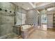 Detailed bathroom including tub with tile surround and glass enclosed shower at 12183 E Mercer Ln, Scottsdale, AZ 85259