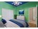 Green bedroom with a ceiling fan, blue ceiling and white closet and drawers at 12183 E Mercer Ln, Scottsdale, AZ 85259