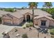 Exterior elevation showcases a beautiful desert home with a three-car garage and meticulously xeriscaped front yard at 12183 E Mercer Ln, Scottsdale, AZ 85259