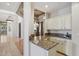 Kitchenette with granite countertops, white cabinets, and bar stool seating in an open concept layout at 12183 E Mercer Ln, Scottsdale, AZ 85259