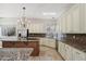 A chef's kitchen features granite counters, tile floors, stainless steel appliances, and a decorative chandelier at 12183 E Mercer Ln, Scottsdale, AZ 85259