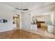 Open floor plan shows wood floor and a view into the kitchen with granite counters and stainless appliances at 12183 E Mercer Ln, Scottsdale, AZ 85259