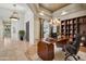 Home office with coffered ceilings, chandelier lighting, custom cabinetry, and built-in desk at 12183 E Mercer Ln, Scottsdale, AZ 85259