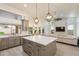 Open kitchen featuring a large island, gray cabinetry, stainless appliances, and stylish pendant lighting at 13361 N 99Th Pl, Scottsdale, AZ 85260