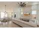 Bright living room with a decorative stone accent wall, large windows, and a comfortable white sofa at 13361 N 99Th Pl, Scottsdale, AZ 85260