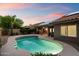 A serene pool with patio and desert landscaping under a beautiful sunset sky at 13361 N 99Th Pl, Scottsdale, AZ 85260
