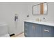 A modern bathroom featuring a blue vanity, quartz countertop, gold hardware and fixtures at 13648 E Aloe Vera Dr, Scottsdale, AZ 85262