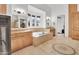 A luxurious bathroom with an oval tub, travertine floors, dual vanities, and a fireplace at 13648 E Aloe Vera Dr, Scottsdale, AZ 85262