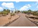 Expansive property showcasing a long, winding brick driveway leading to a beautiful home with lush desert landscaping at 13648 E Aloe Vera Dr, Scottsdale, AZ 85262