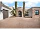 Elegant front entrance with stone archway, wrought iron gate, and meticulously maintained brick driveway at 13648 E Aloe Vera Dr, Scottsdale, AZ 85262