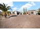Stunning home featuring a stone and stucco exterior, a spacious brick driveway, and mature desert landscaping with palm trees at 13648 E Aloe Vera Dr, Scottsdale, AZ 85262