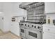 Chef's kitchen with stainless steel appliances, white cabinets, and a professional range at 13648 E Aloe Vera Dr, Scottsdale, AZ 85262