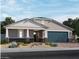 Charming single-story home with stone accents and a two-car garage under a partly cloudy blue sky at 15963 W El Cortez Pl, Surprise, AZ 85387