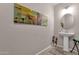 Stylish half bathroom with a pedestal sink, modern fixtures, and contemporary artwork at 16105 N 183Rd Dr, Surprise, AZ 85388