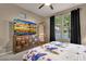 Bedroom with carpeted floors, ceiling fan and large TV; bathed in natural light from a large window at 16105 N 183Rd Dr, Surprise, AZ 85388