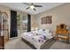 Cozy bedroom with a ceiling fan, carpeted floors, and a large window overlooking the backyard at 16105 N 183Rd Dr, Surprise, AZ 85388