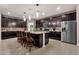 Open kitchen with dark wood cabinetry, granite countertops, an island with seating, and stainless steel appliances at 16105 N 183Rd Dr, Surprise, AZ 85388
