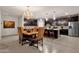 Open-concept kitchen with dark cabinetry, center island, and adjacent dining area with ornate chandelier at 16105 N 183Rd Dr, Surprise, AZ 85388
