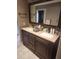 Bathroom with double sinks, granite countertops, and dark wood cabinetry at 16805 S 29Th Pl, Phoenix, AZ 85048
