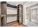 Walk-in closet with custom shelving and a view into a luxurious glass shower at 16805 S 29Th Pl, Phoenix, AZ 85048