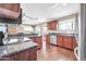 Updated kitchen features stainless steel appliances, granite countertops, dark wood cabinetry, and wood flooring at 16805 S 29Th Pl, Phoenix, AZ 85048