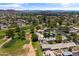 An aerial view showcases a community near a golf course with mature trees and desert mountain backdrop at 18206 N 45Th Ave, Glendale, AZ 85308