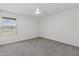 Spacious carpeted bedroom with a bright window and a ceiling fan at 18206 N 45Th Ave, Glendale, AZ 85308
