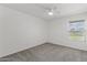 Neutral carpeted bedroom with a ceiling fan and a bright window for natural light at 18206 N 45Th Ave, Glendale, AZ 85308