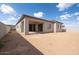 Spacious backyard with dirt landscaping, patio area and view of the blue sky at 1903 E Empeltre Rd, San Tan Valley, AZ 85140