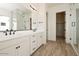 Modern bathroom featuring a dual sink vanity, wood-look flooring, and a glass-enclosed shower at 1903 E Empeltre Rd, San Tan Valley, AZ 85140